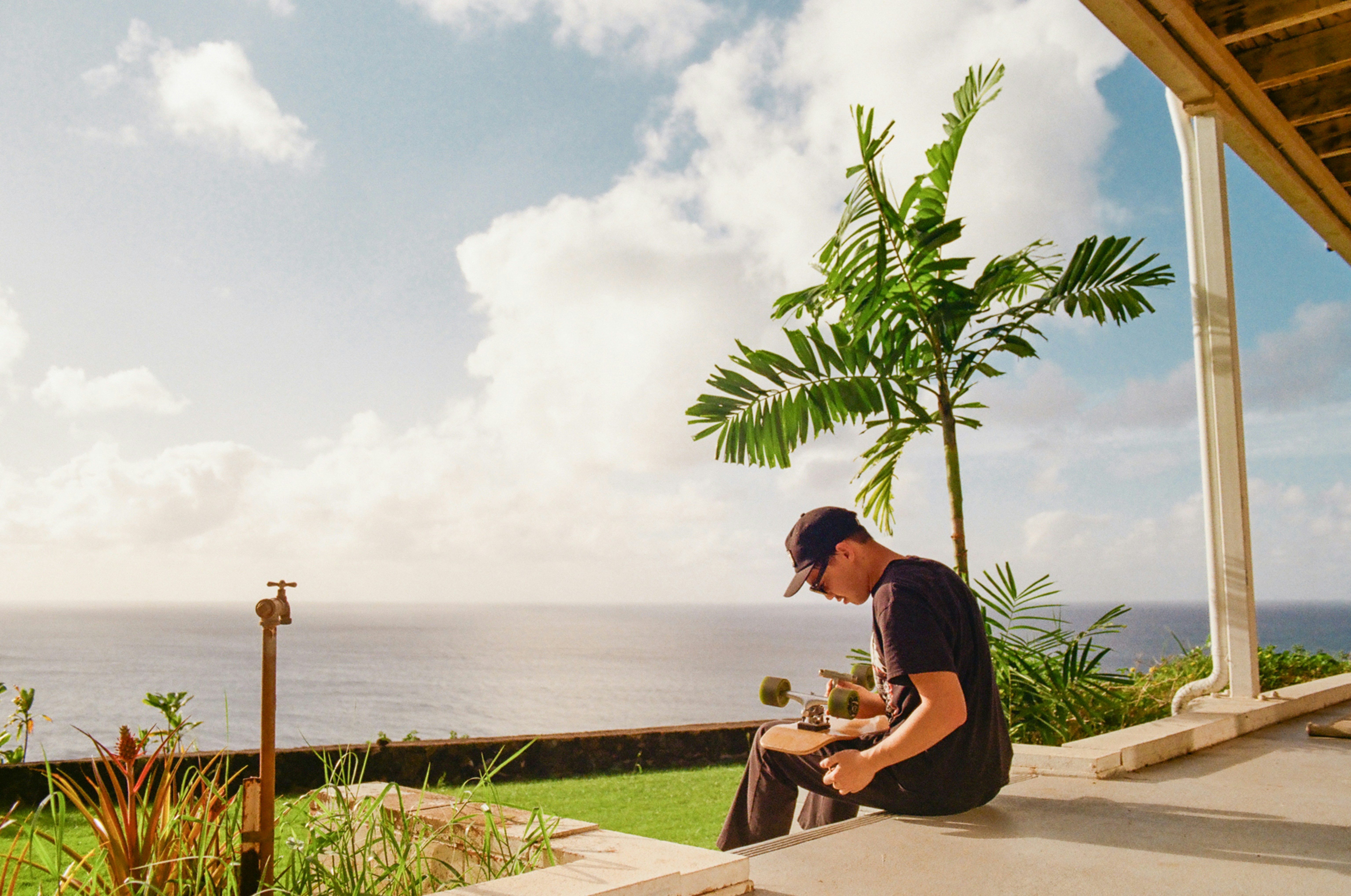 Mann sitzt auf Veranda mit Blick auf das Meer