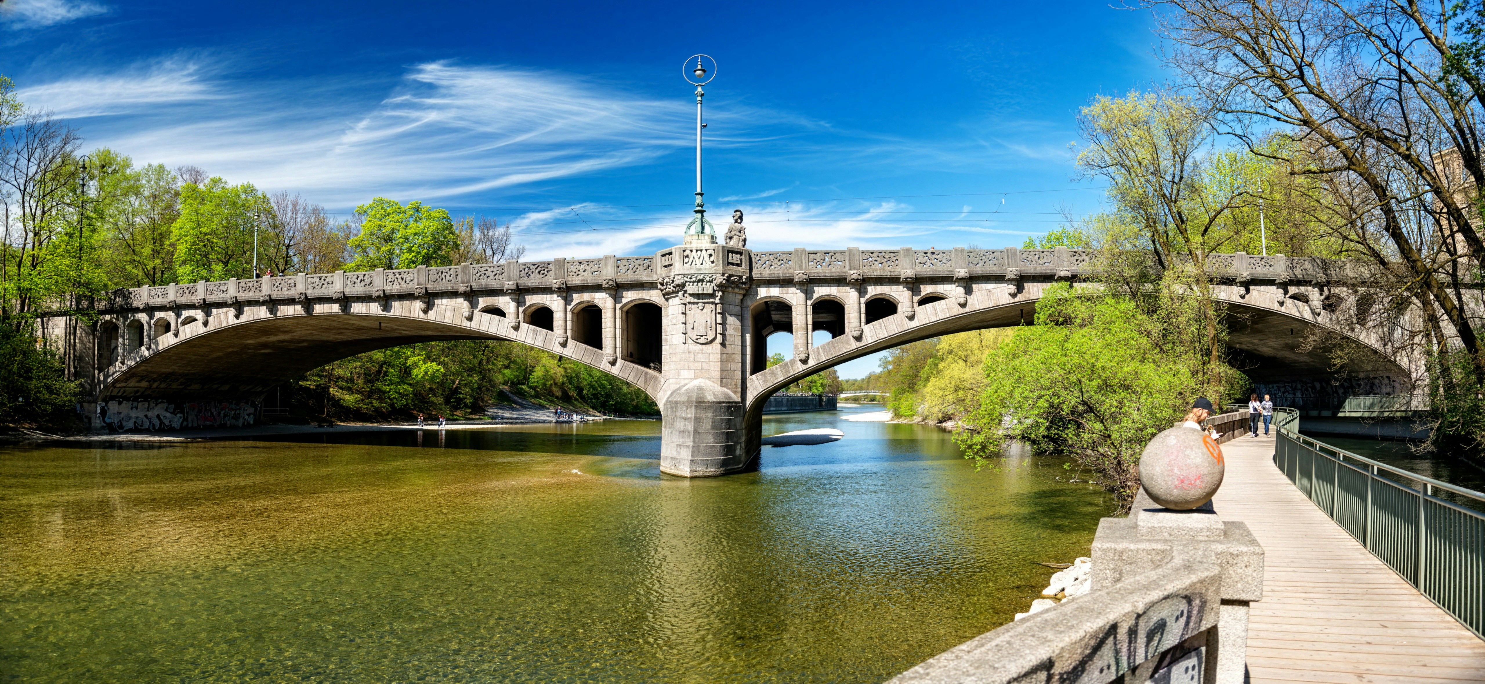 Stone bridge over a river with lush green trees
