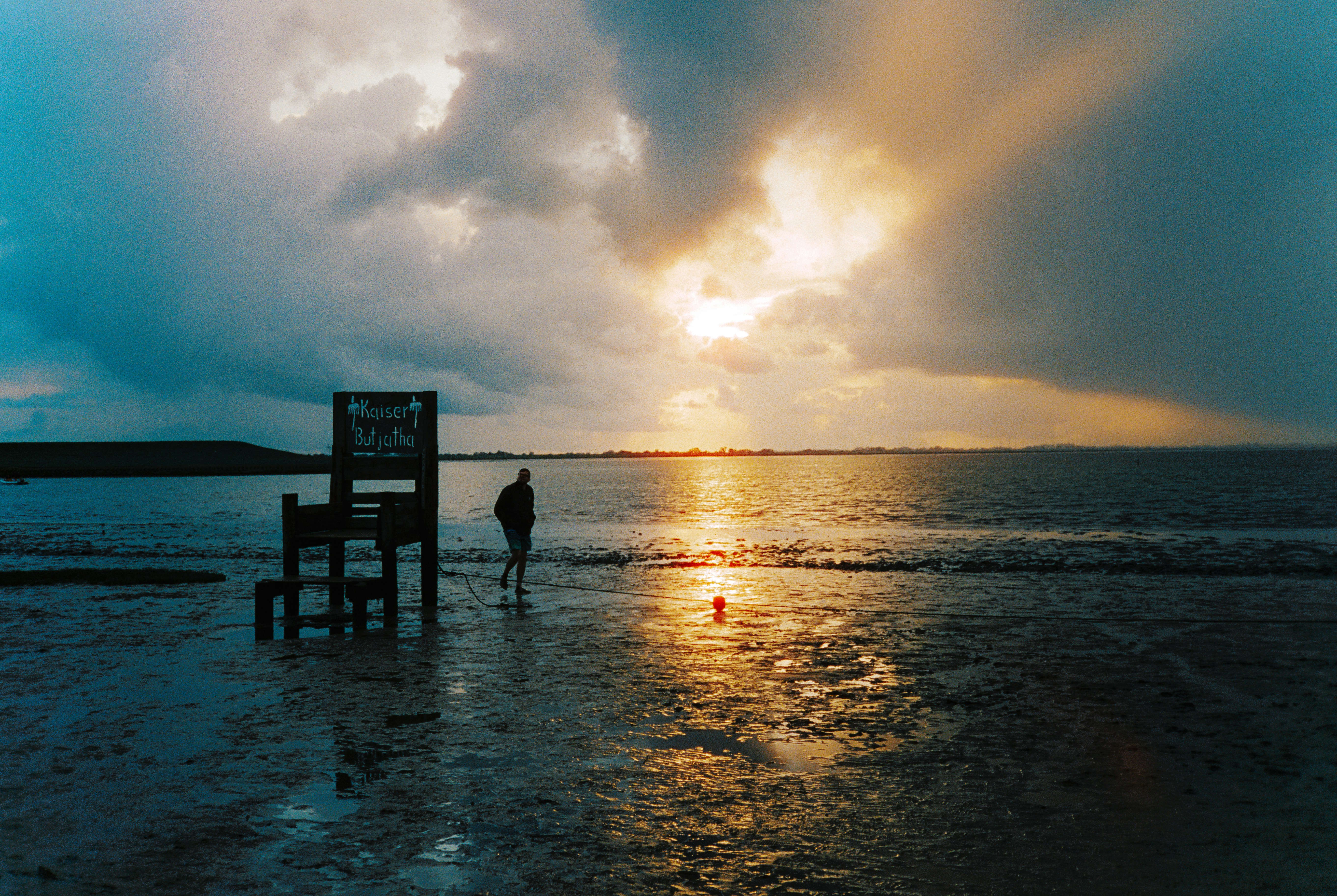 Person standing on a beach at sunset