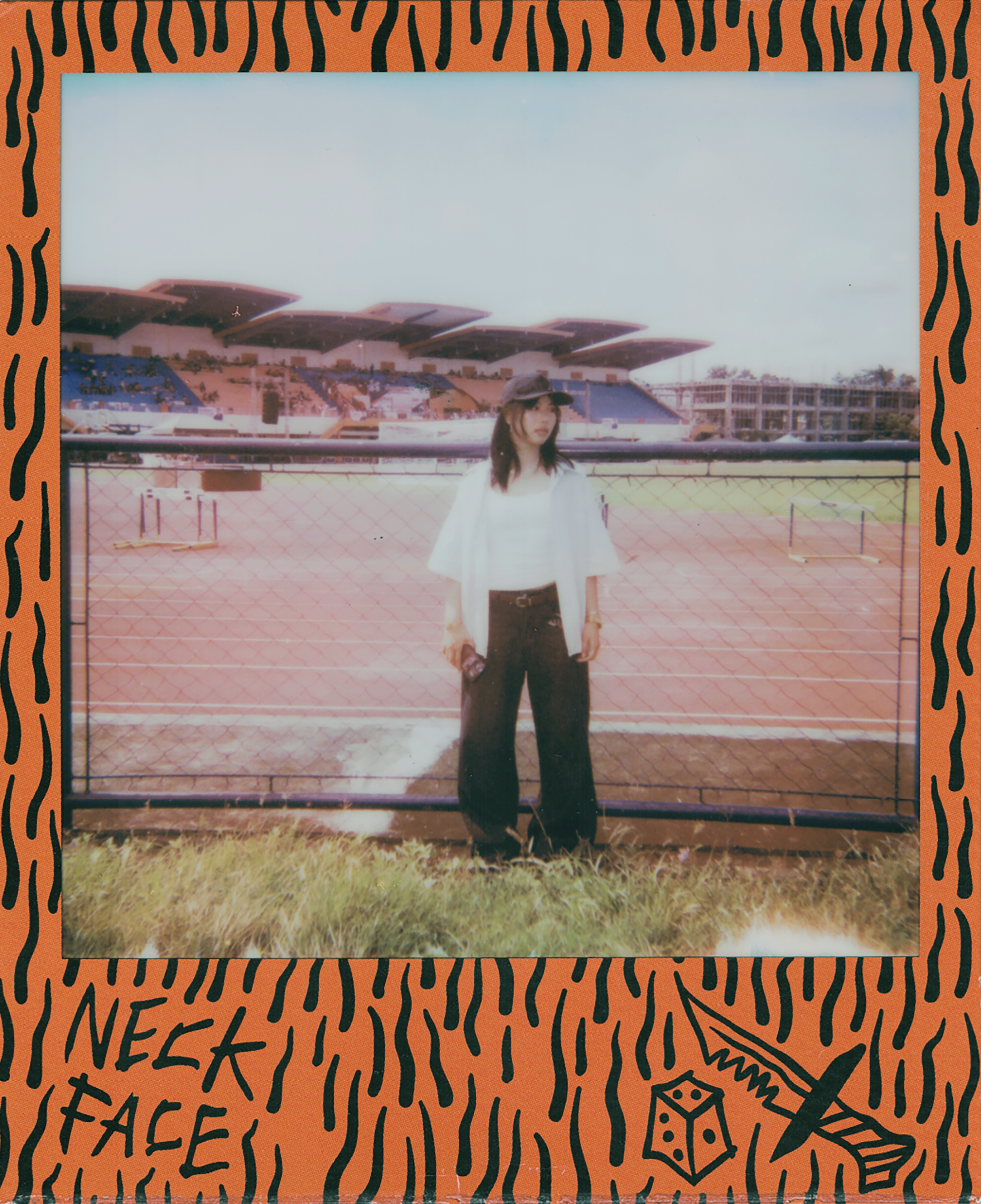 Young woman stands near a stadium track.