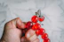Hand holding a string of red amber beads