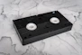 A black vhs tape on a marble background