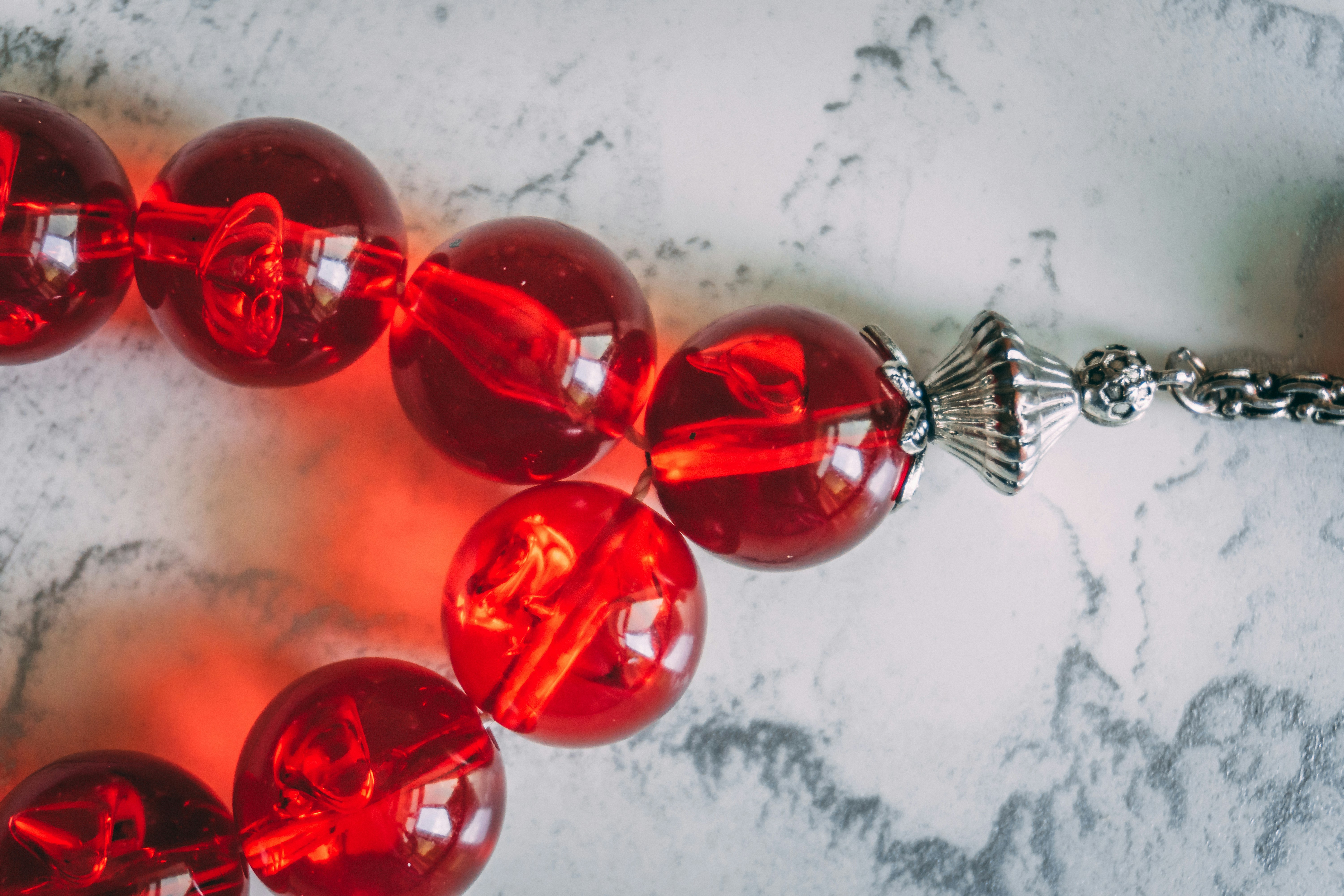 Close-up of translucent red beads with silver accent