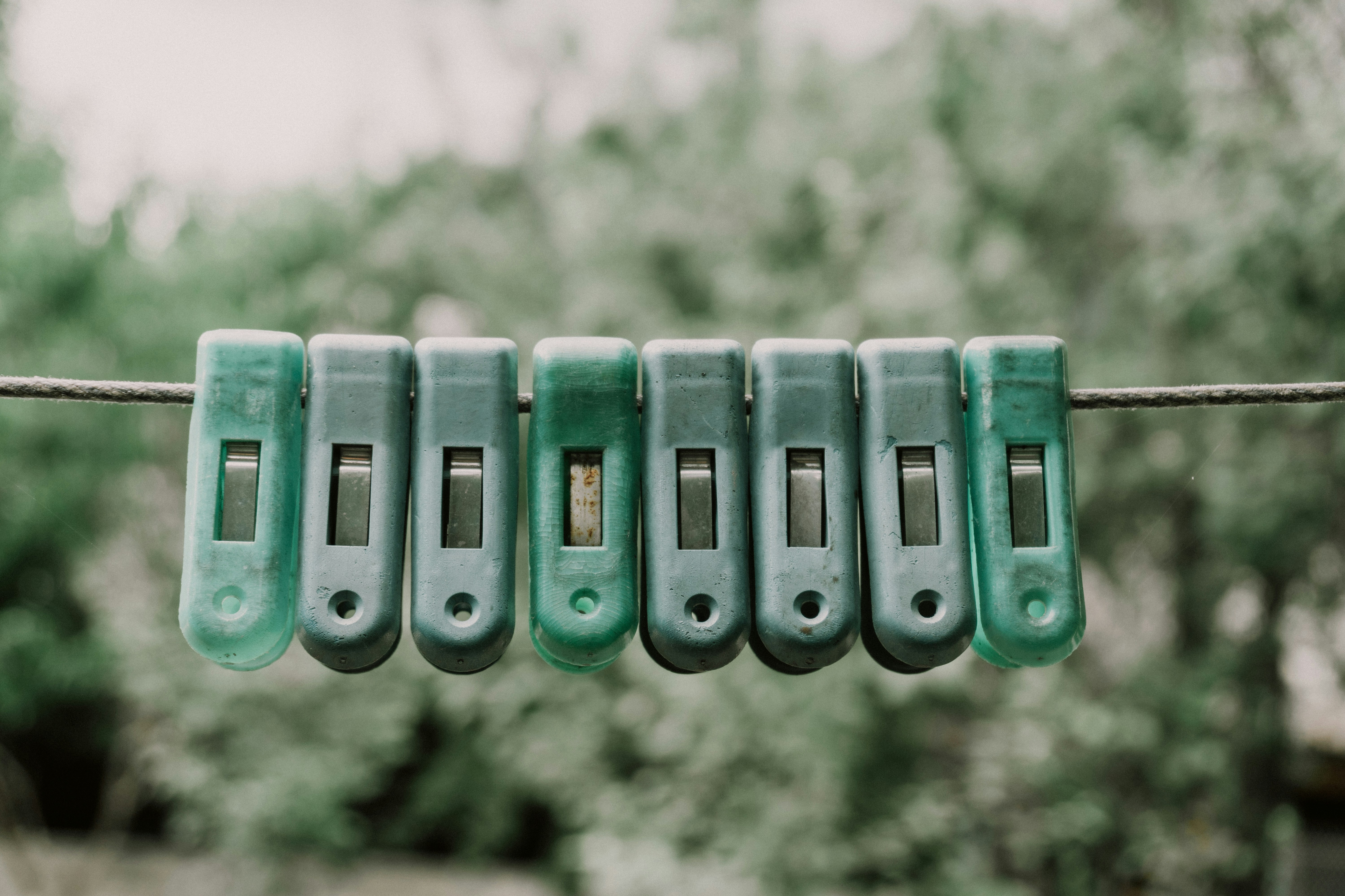 Green clothespins lined up on a wire