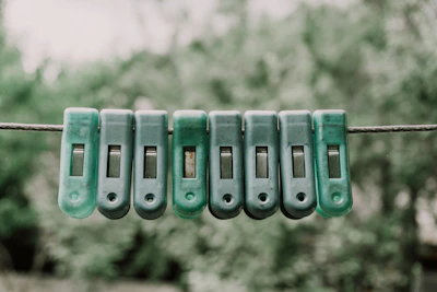 Green clothespins lined up on a wire