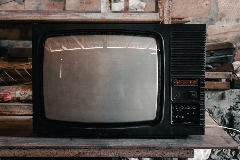 Ancien téléviseur à tube cathodique, écran éteint, posé sur une étagère en bois dans un atelier (photo d’illustration)