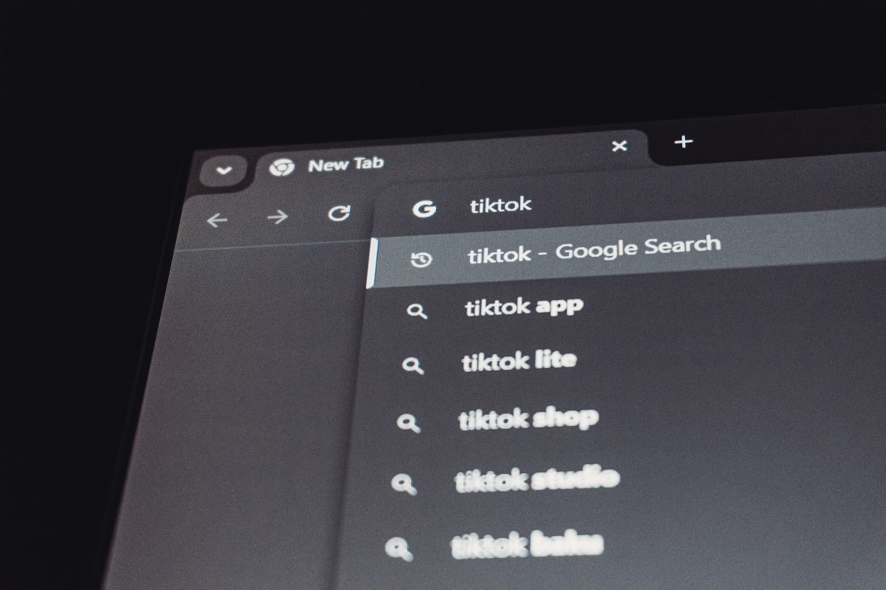 Chrome new tab with Google search bar showing autosuggest dropdown for tiktok — the redesigned search experience under AI Mode Search