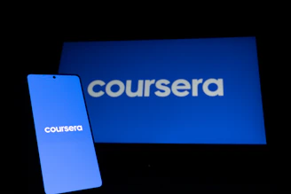 Coursera logo on phone and laptop screen