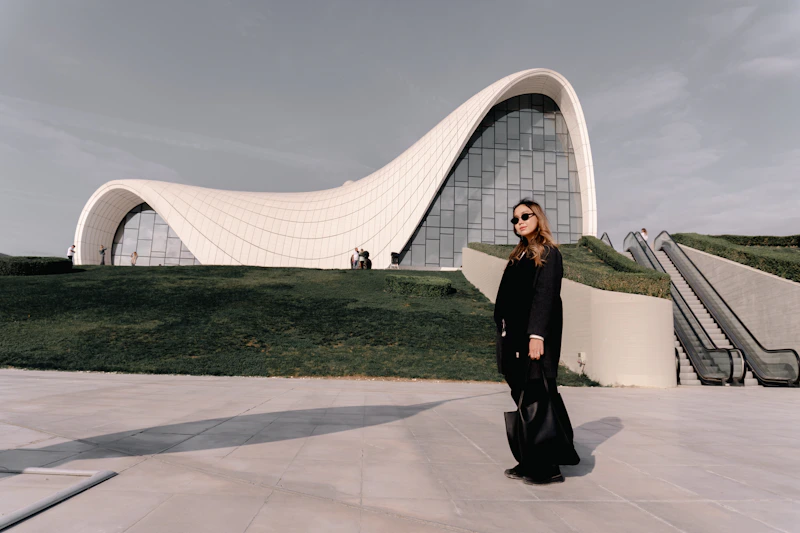 woman standing before a modern curved building