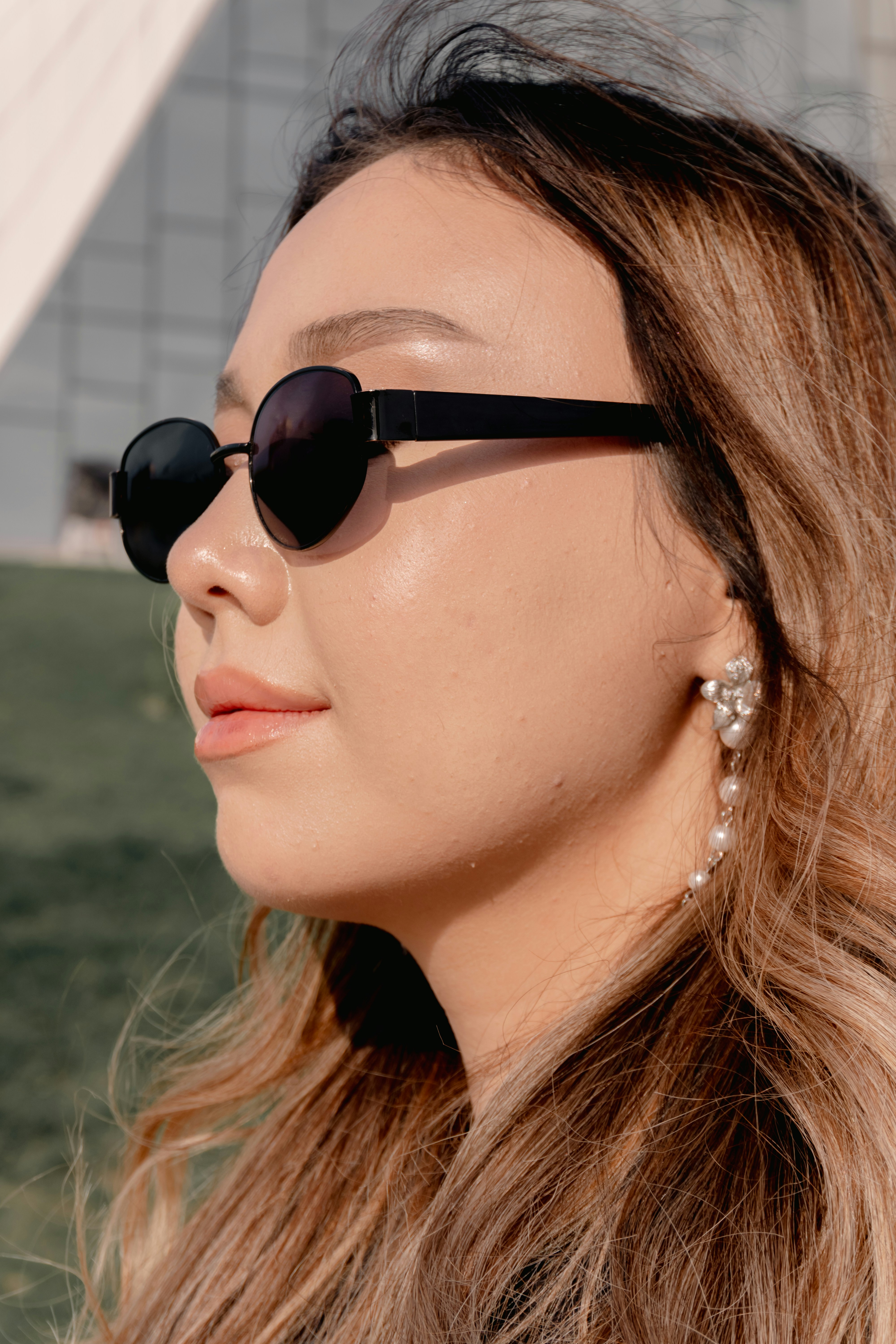 Young woman with sunglasses and pearl earrings