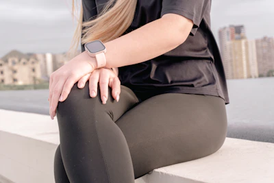 Woman in athletic wear sitting outdoors near water