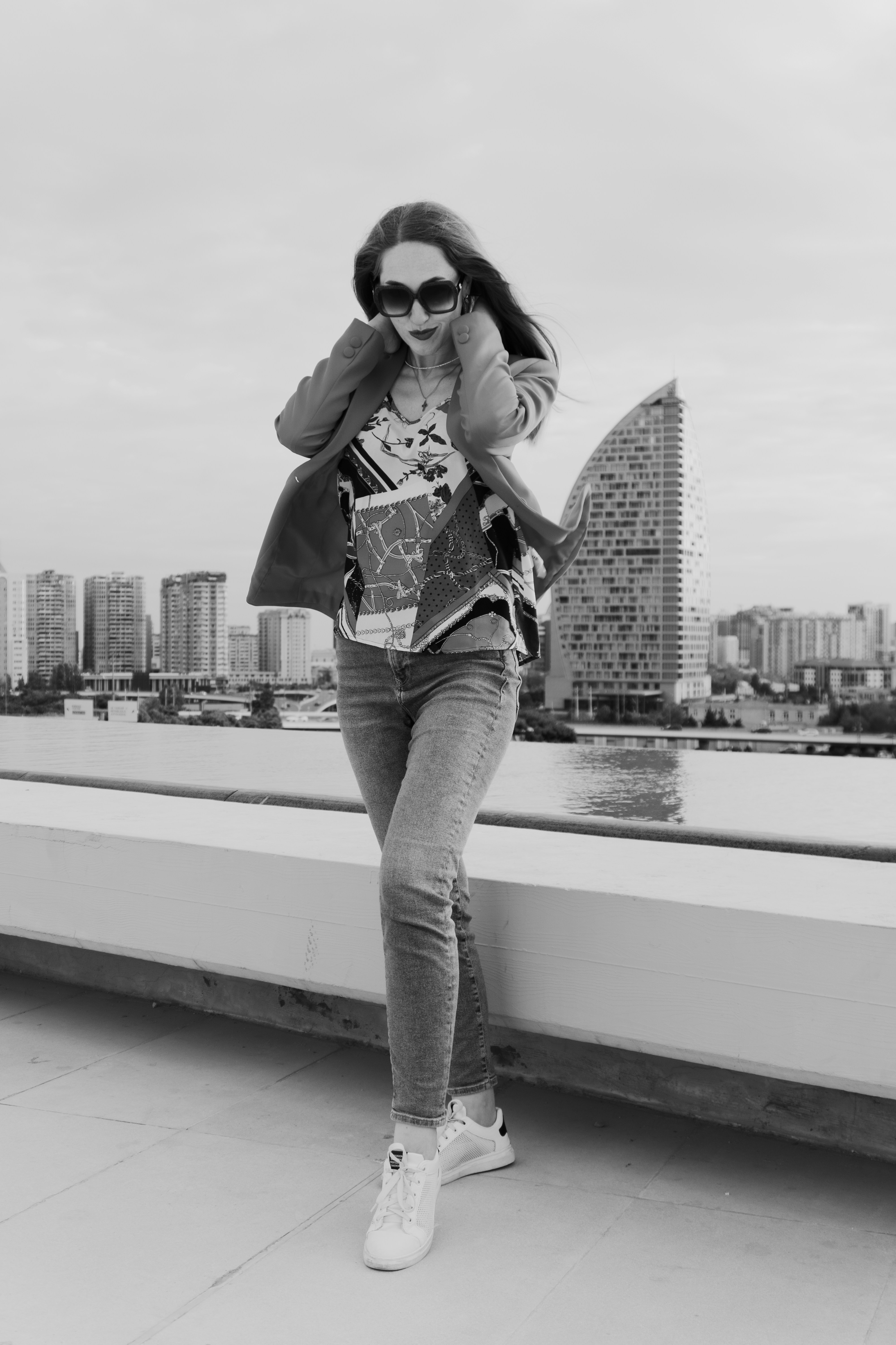 Woman in stylish outfit on rooftop with city skyline