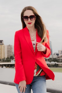 Woman in red blazer and sunglasses outdoors