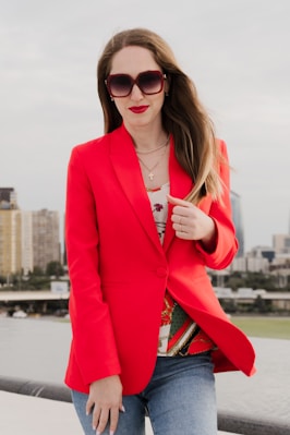 Woman in red blazer and sunglasses outdoors