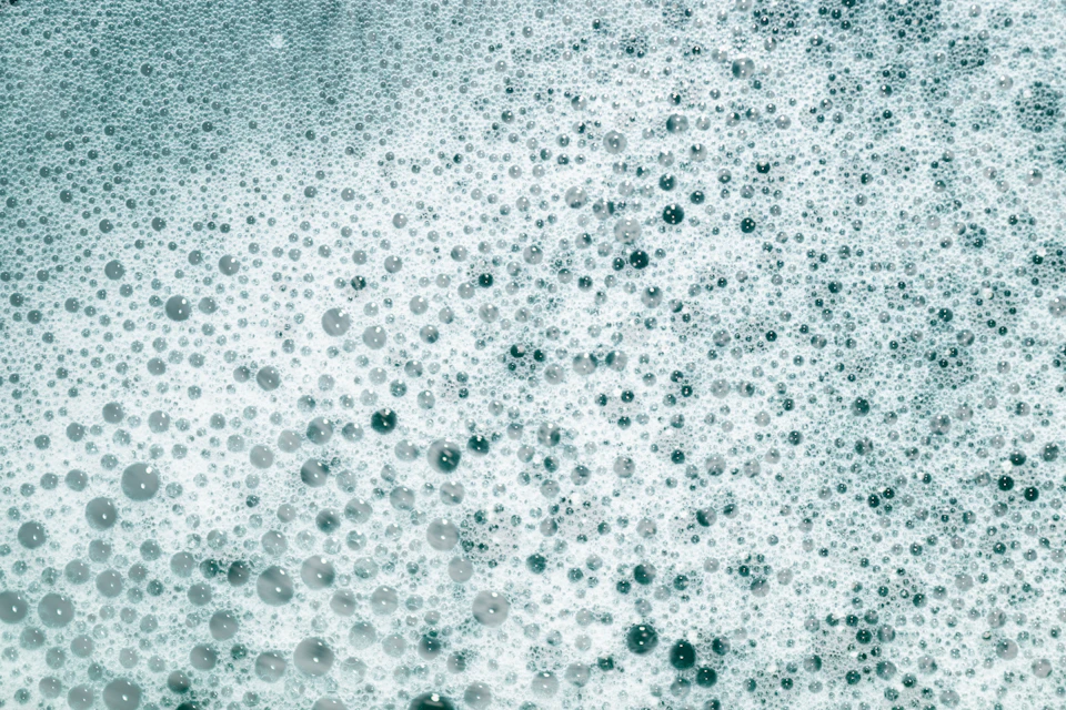 Close-up view of surface covered with numerous small white and blue bubbles
