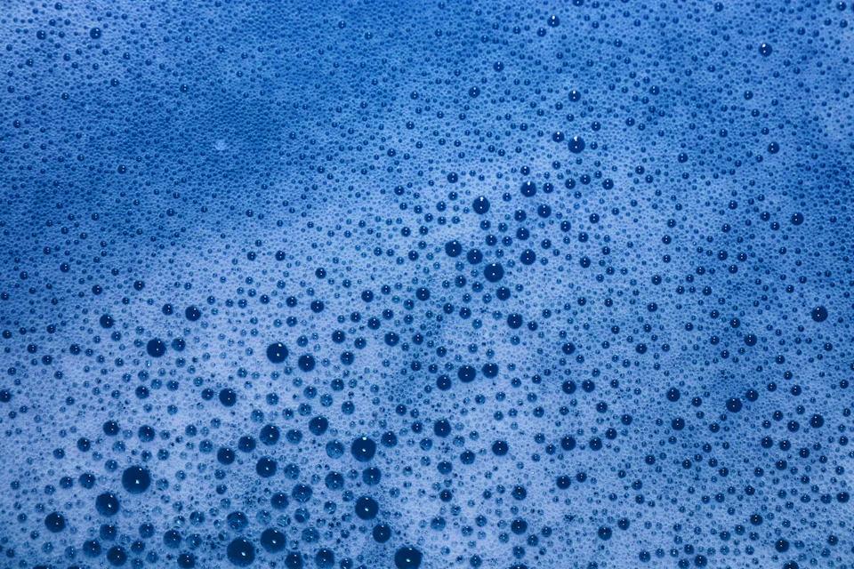 Close-up view of a blue surface with numerous small white dots scattered across it