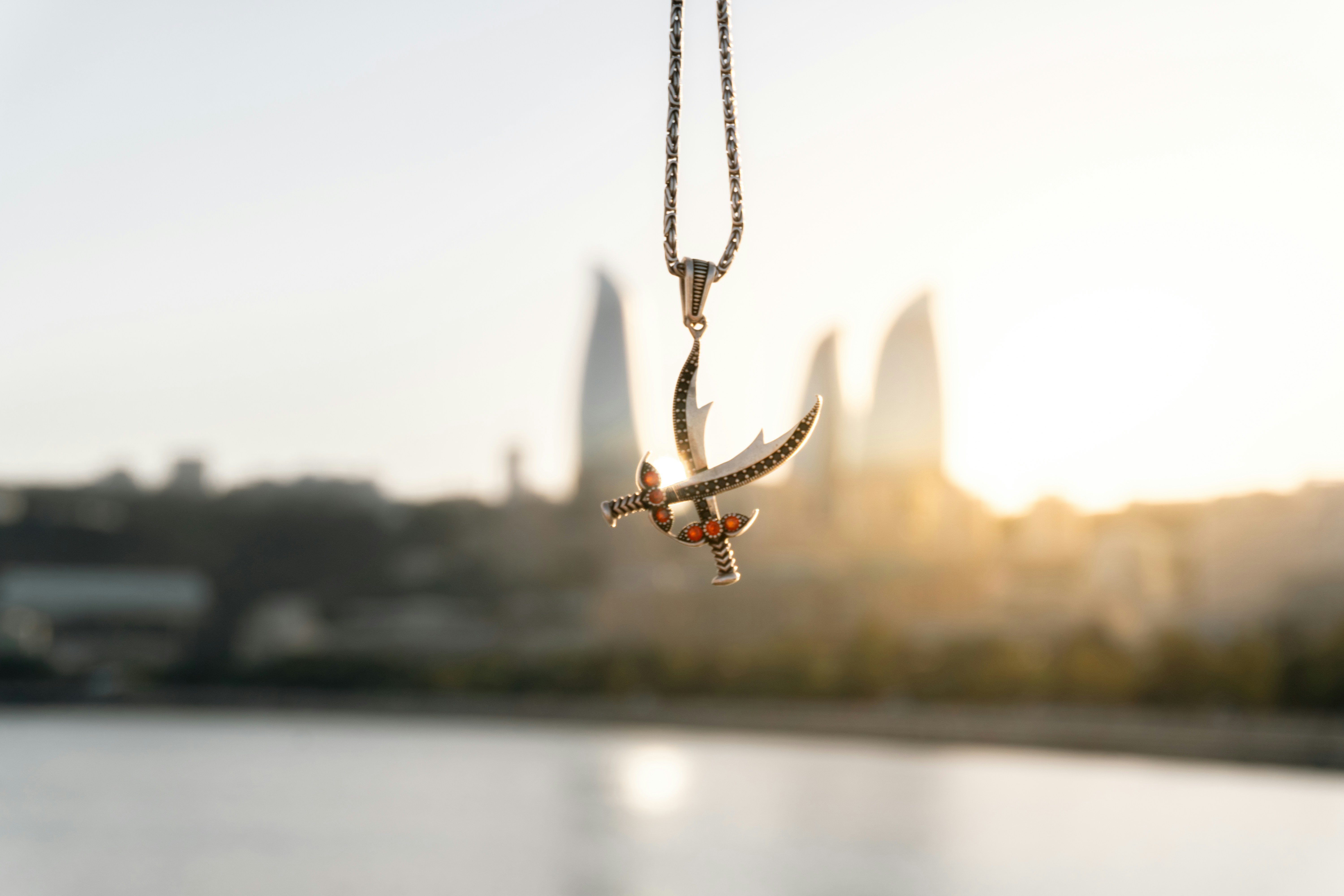 Silver airplane pendant with cityscape background