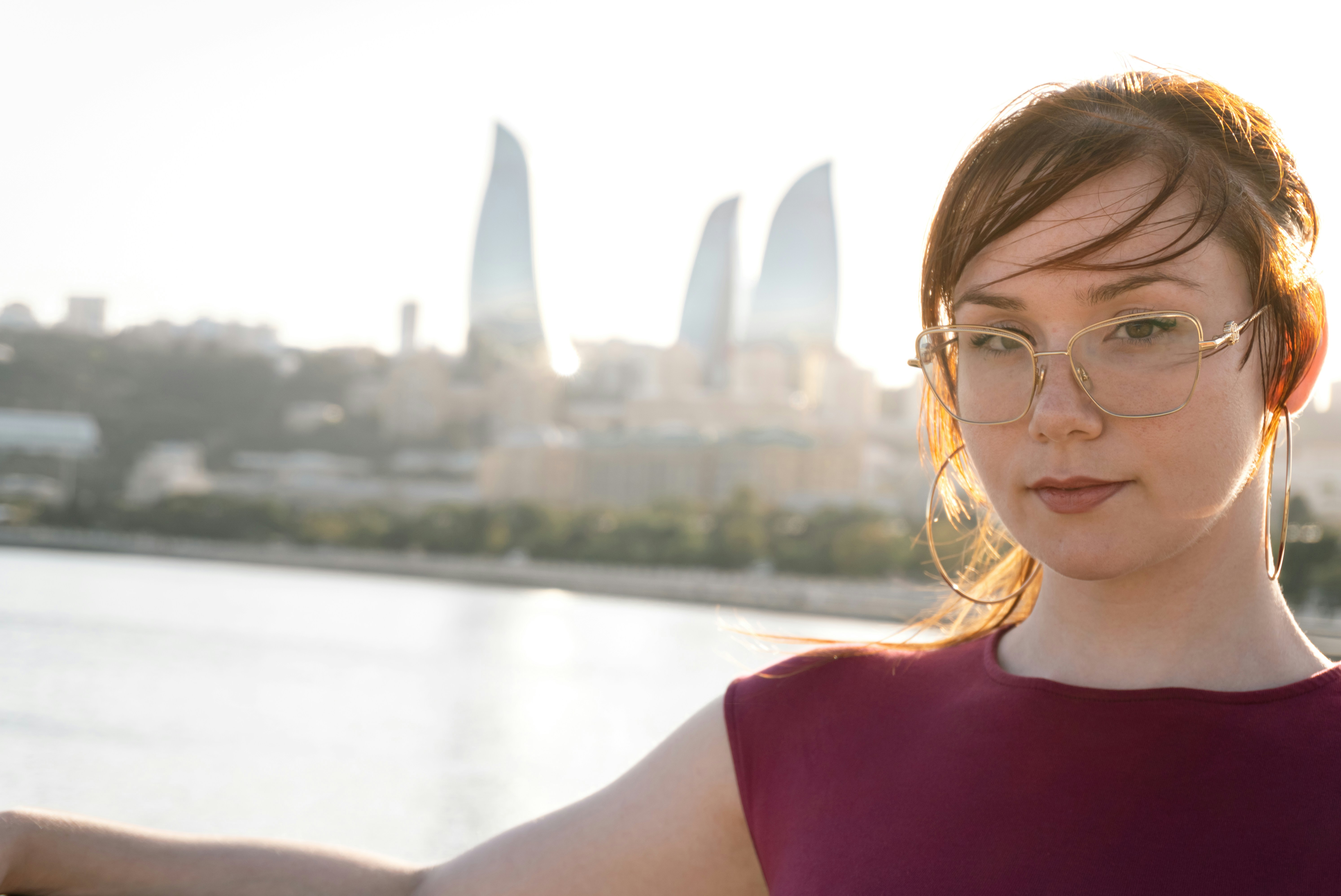 Woman with glasses in front of flame towers