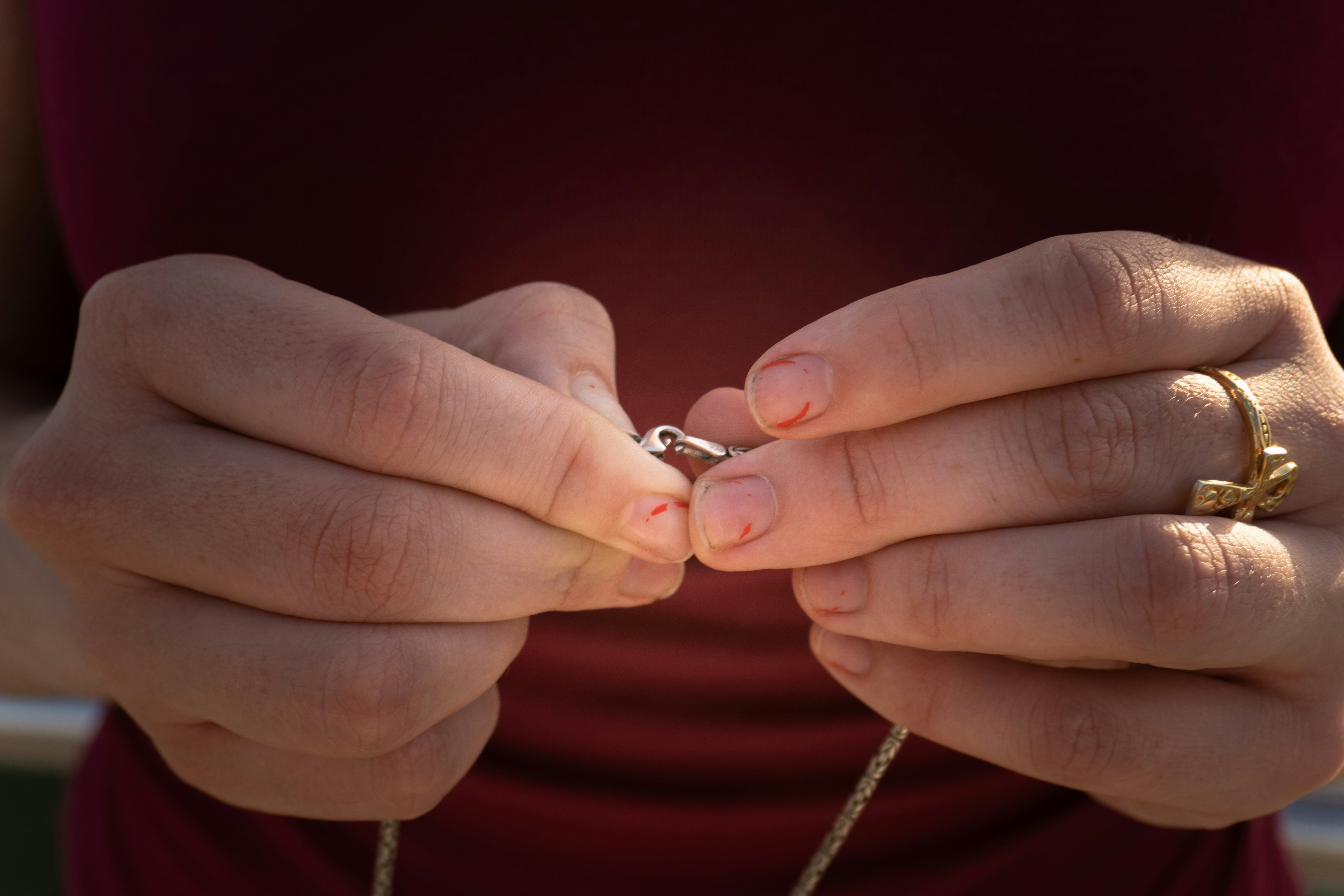 Woman fastens a necklace clasp with her hands