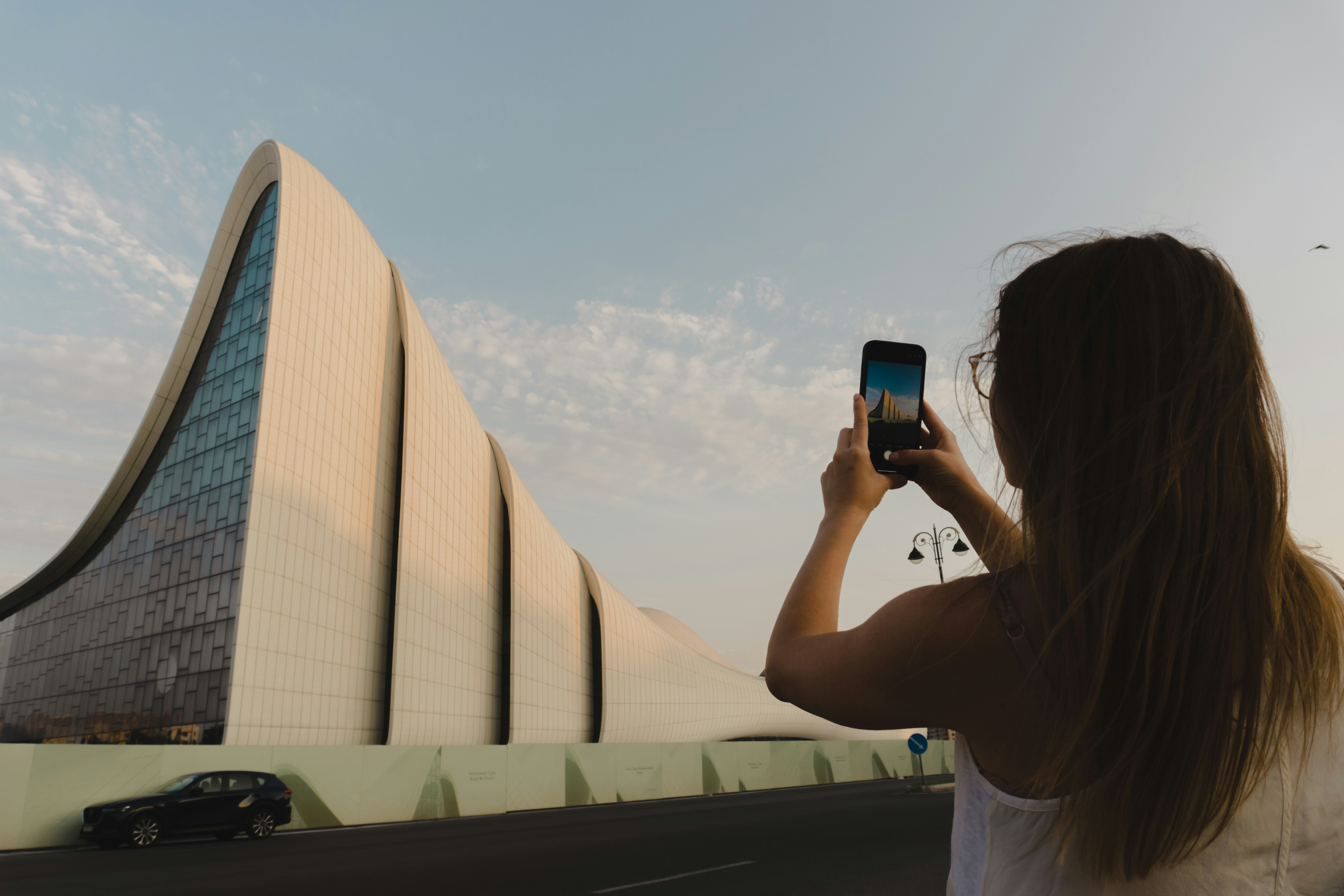 Woman taking a picture of a modern building