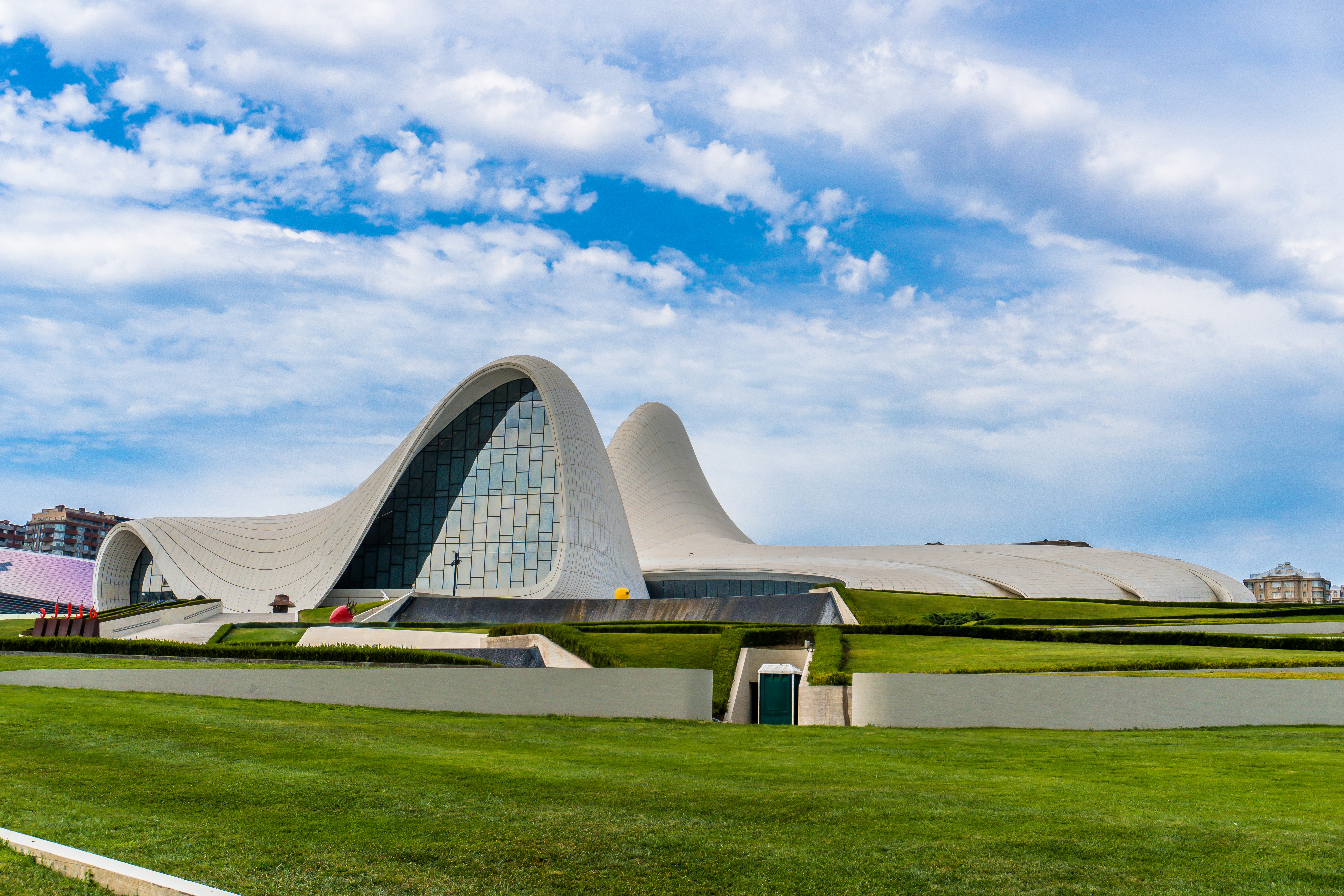 Modern white building with wavy architecture under blue sky
