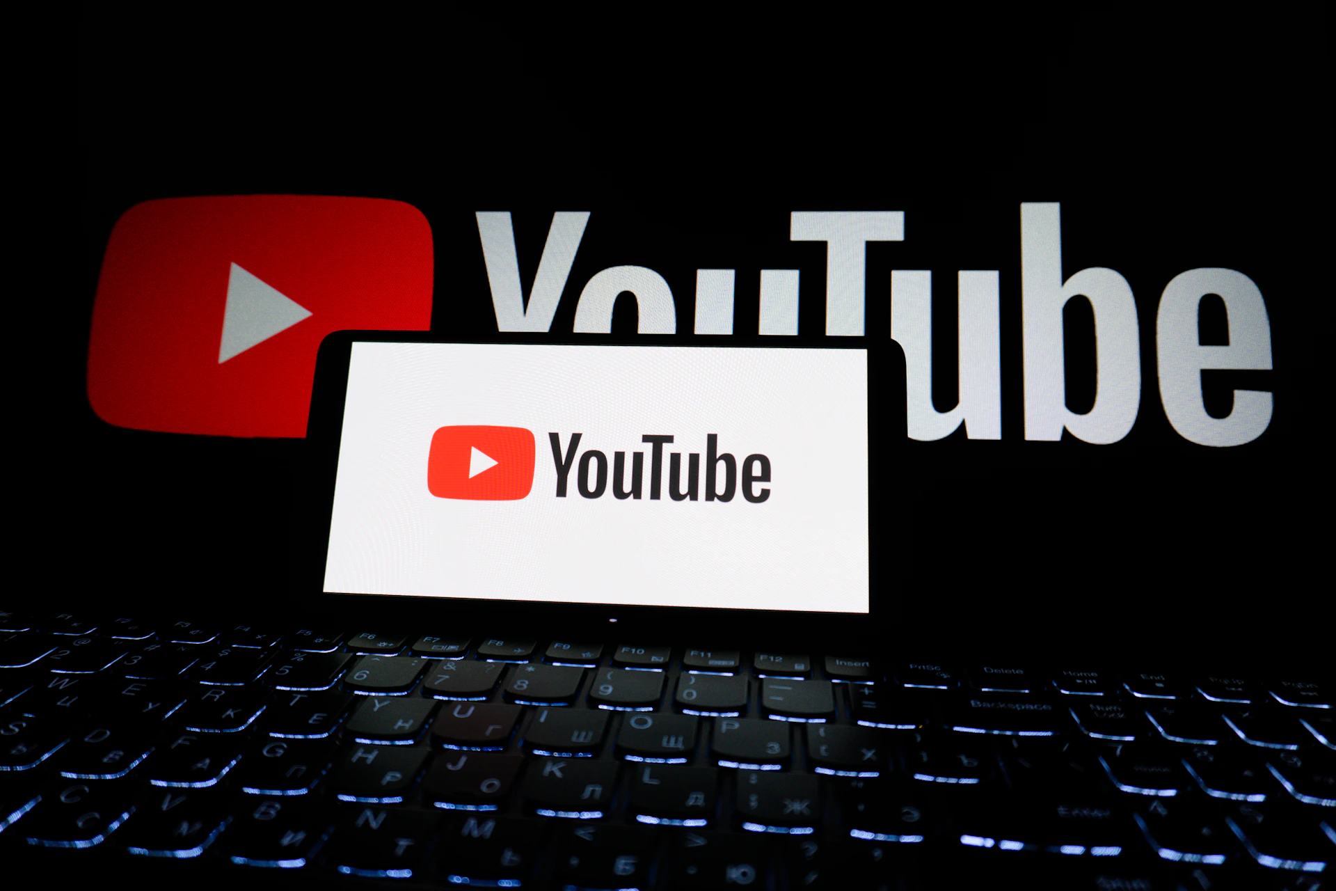 Youtube logo displayed on a phone and screen.