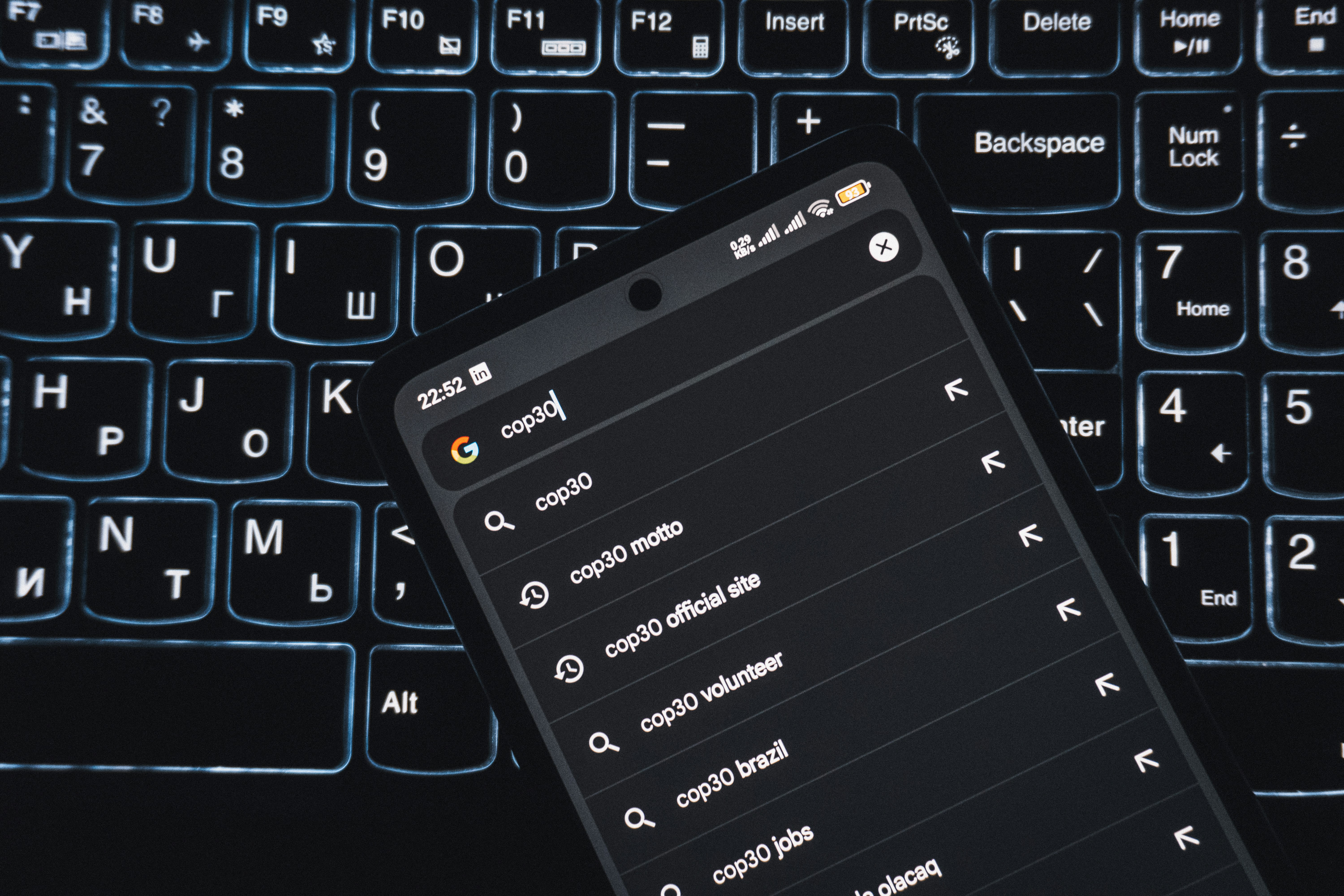 Smartphone displaying search results on a keyboard