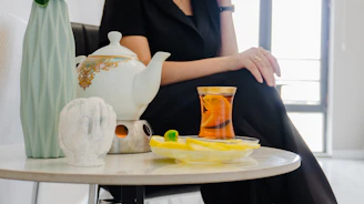 A person sitting by a table with tea and snacks.