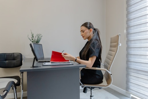 Woman working at a desk with a laptop and laptop.