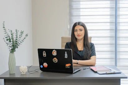 Woman sitting at a desk with a laptop.