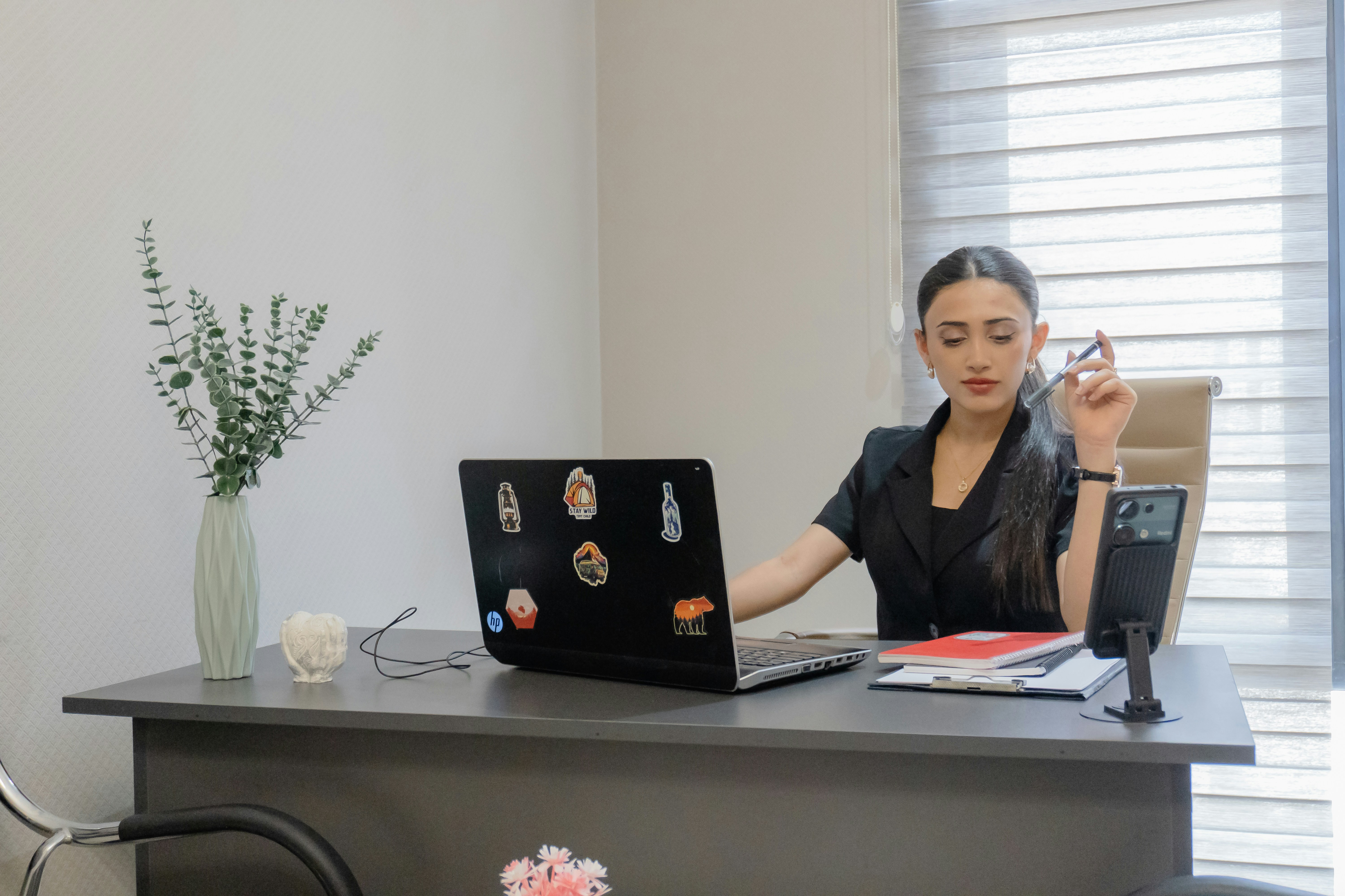 Woman working at desk with laptop and phone