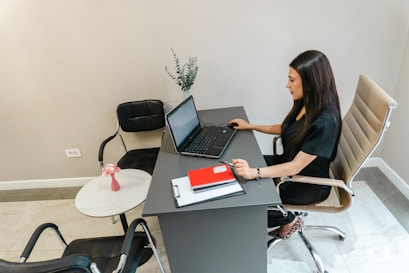 Woman working at a desk with a laptop.