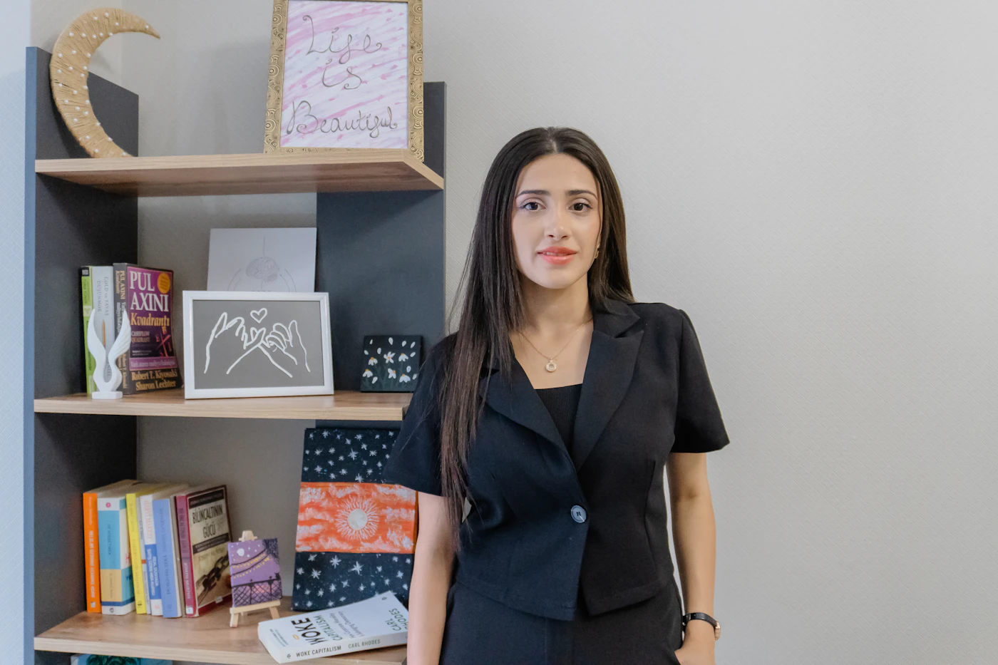 Dr. Leyla Karim standing beside the bookshelf in her office