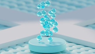 Clear water droplets falling onto a light blue podium.