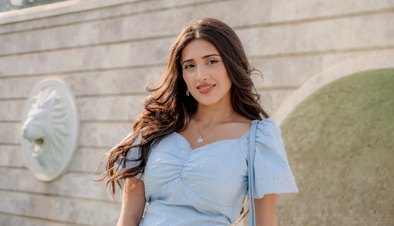 joven con melena ondulada y vestido azul