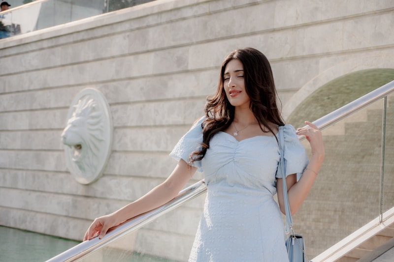 Elegant woman in light blue dress on stairs