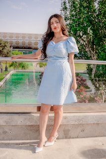 Woman in a light blue dress standing outdoors