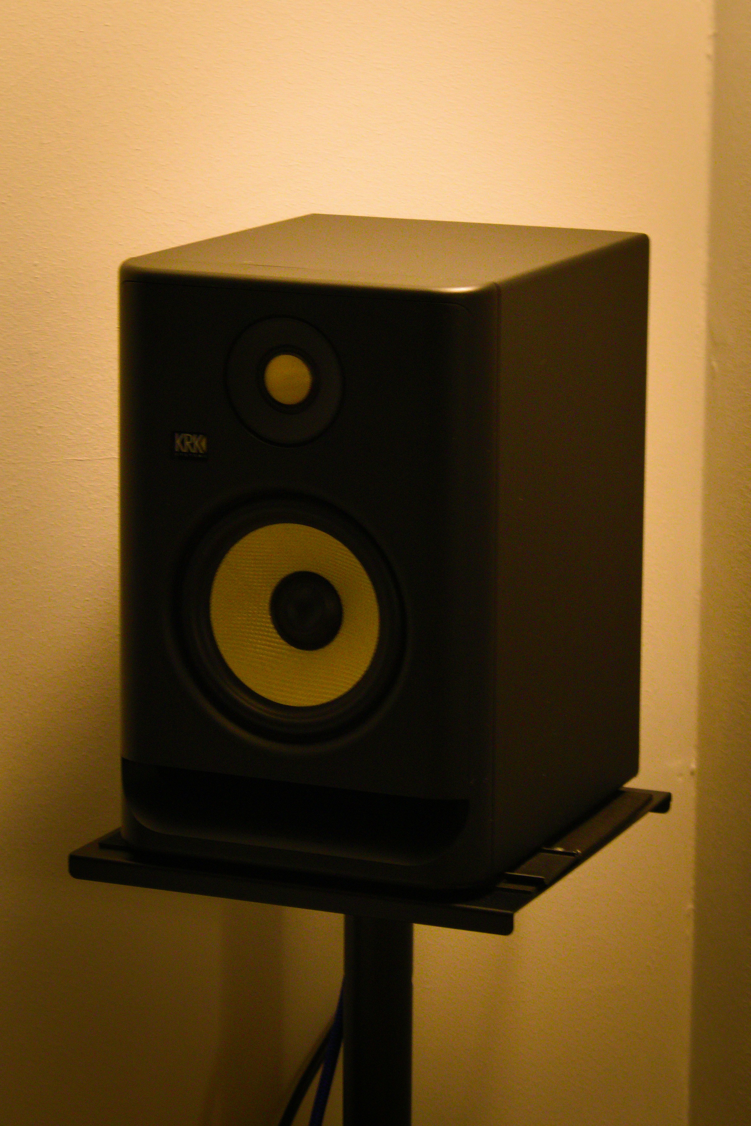 A black studio monitor speaker with yellow accents.