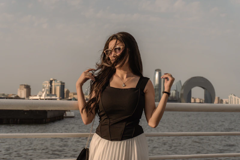 A young, affluent woman with long dark hair and designer sunglasses
