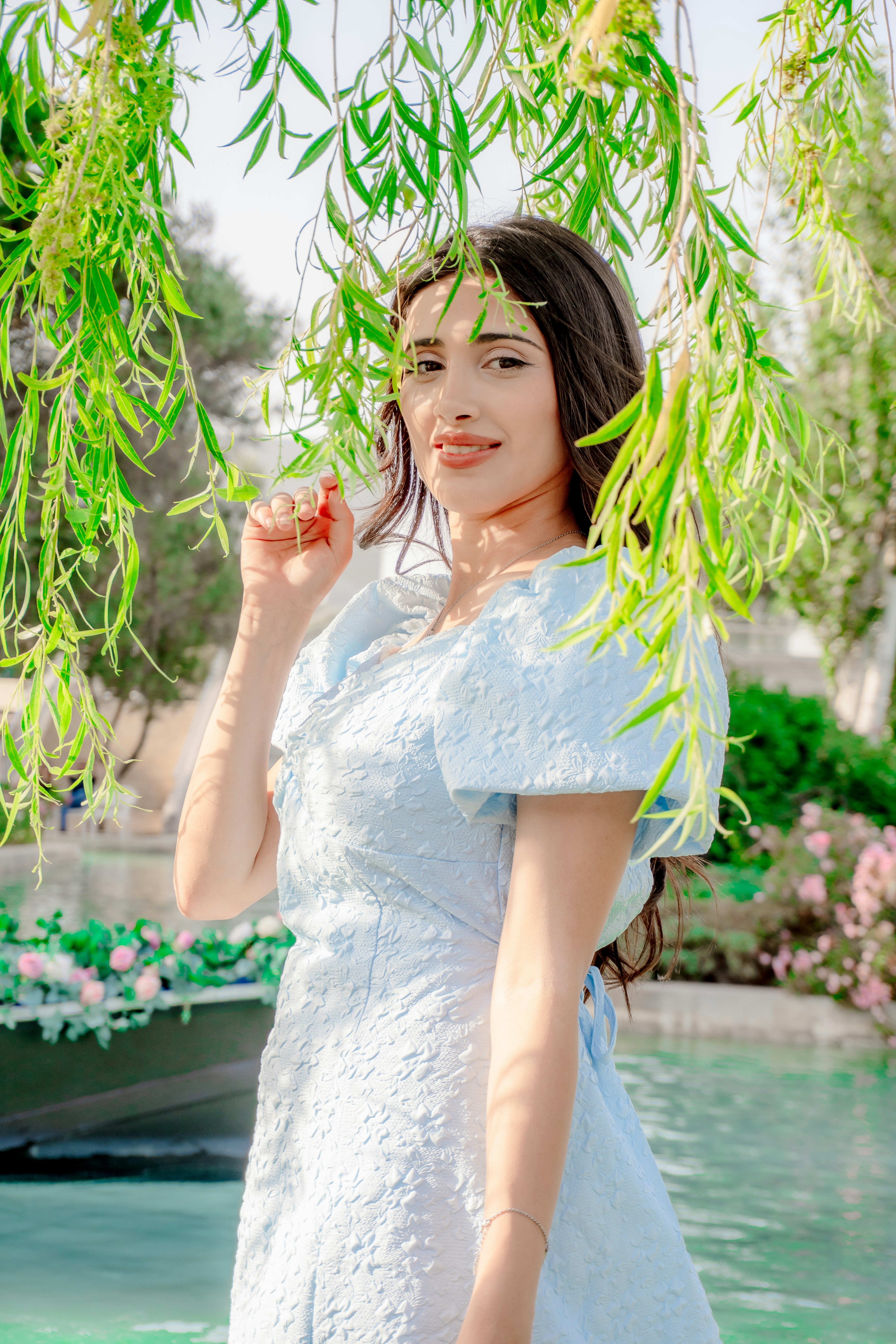 Frau in hellblauem Kleid in der Nähe von Wasser und Grün
