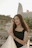 Young woman in black dress with city skyline background