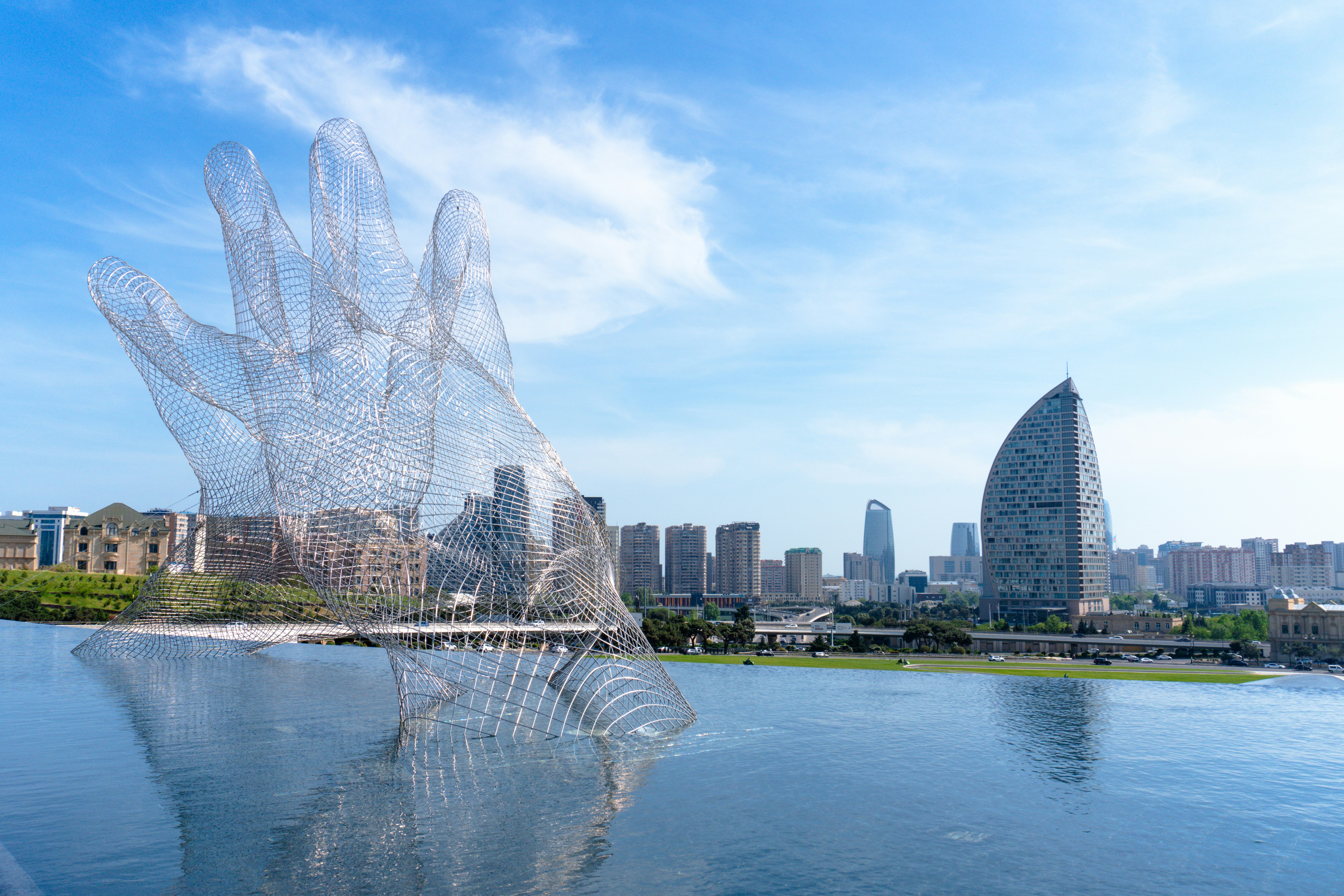 Wireframe hand sculpture with city skyline reflection