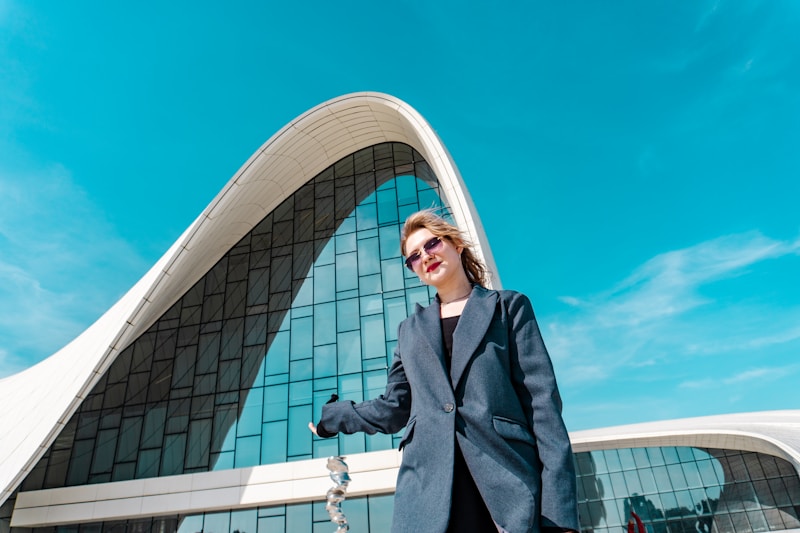 vacker kvinna i solglasögon framför modern byggnad