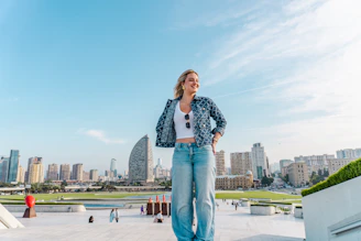 Woman standing on rooftop with city skyline behind her