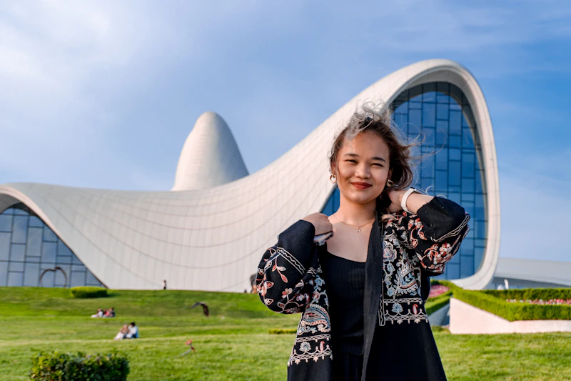 woman posing confidently in front of modern architecture