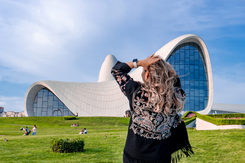 stylish woman with hands in hair by a modern building