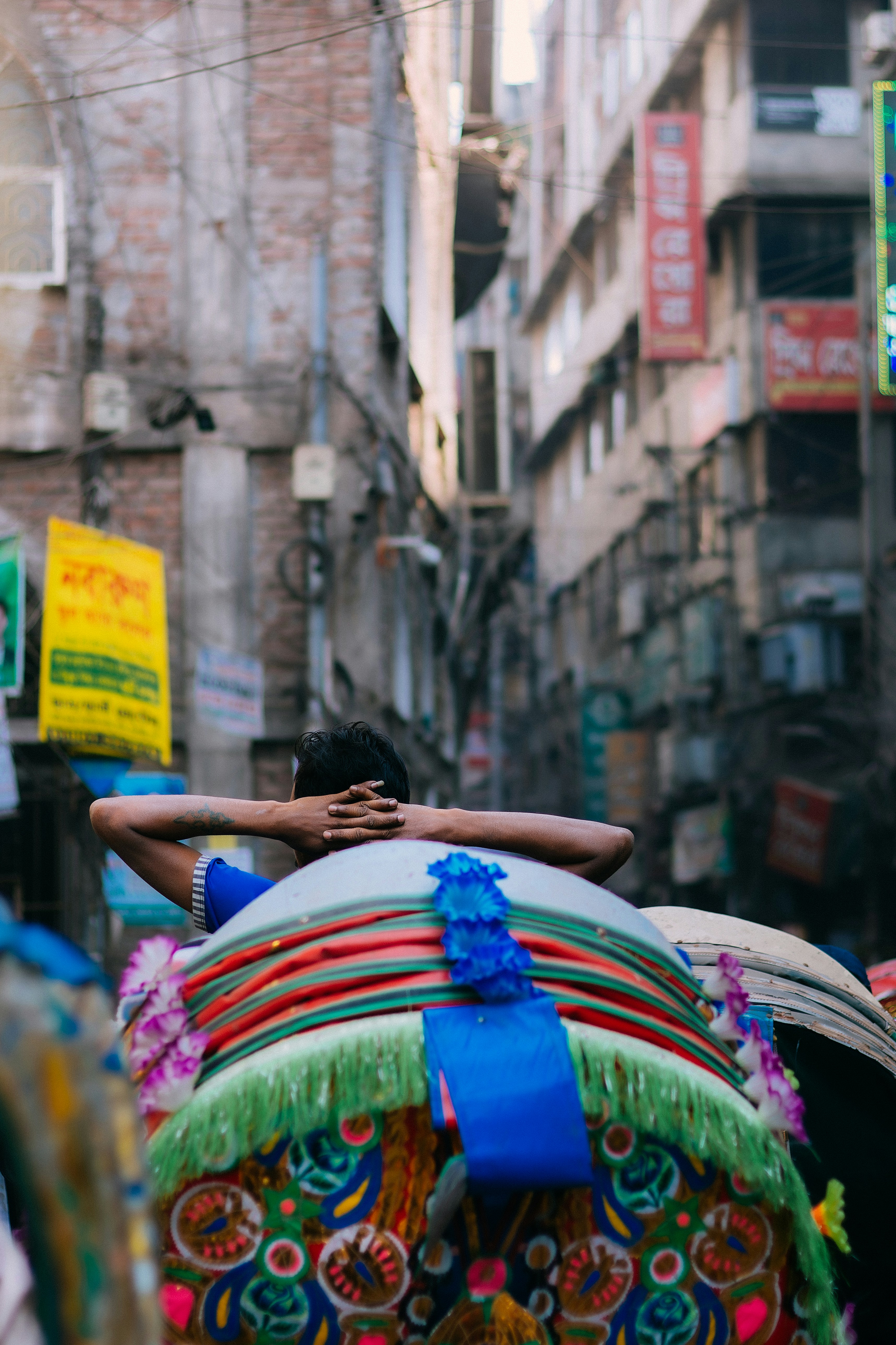 Rikscha-Fahrer ruht sich mit den Händen hinter dem Kopf aus