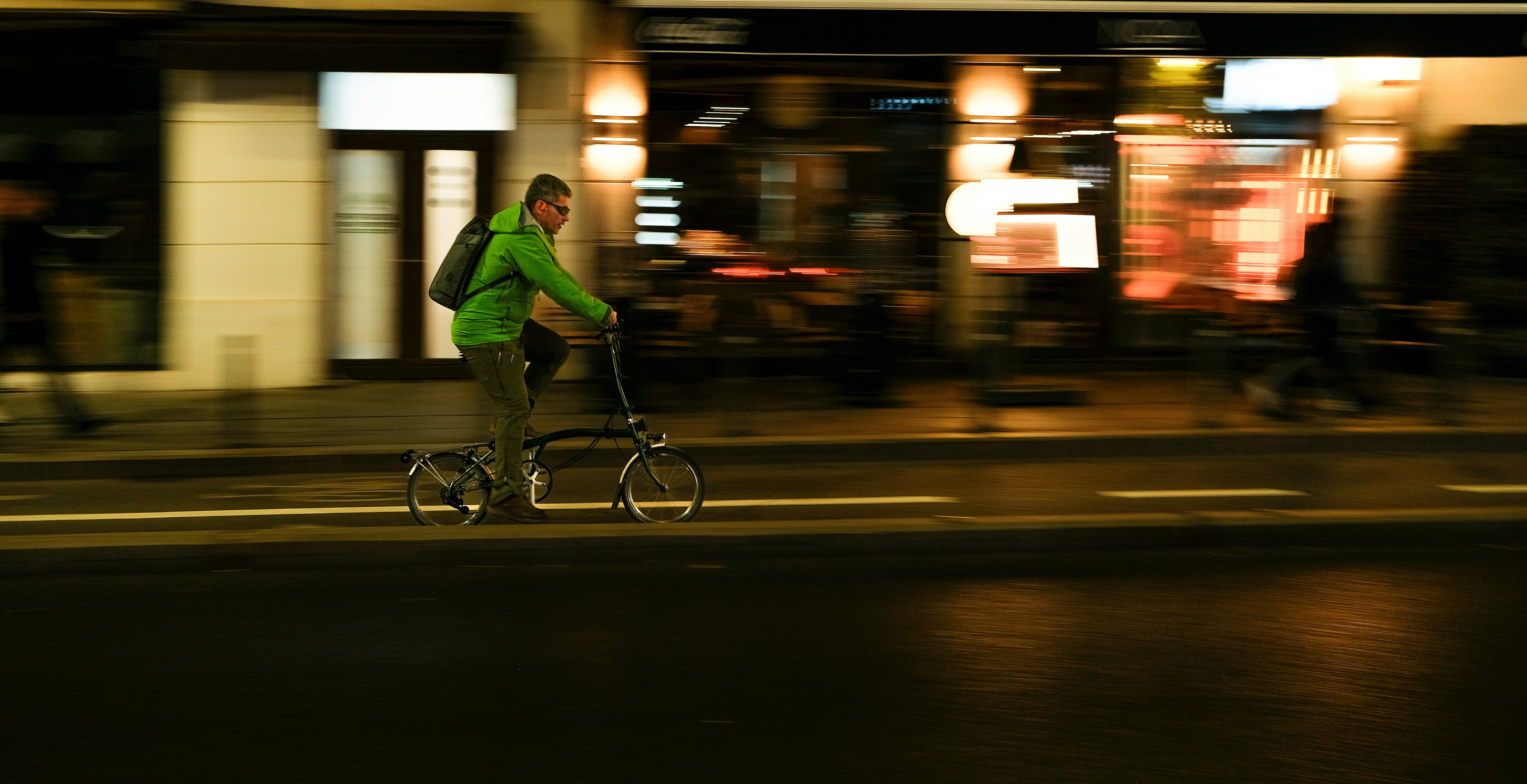 Man riding a bicycle on a city street at night