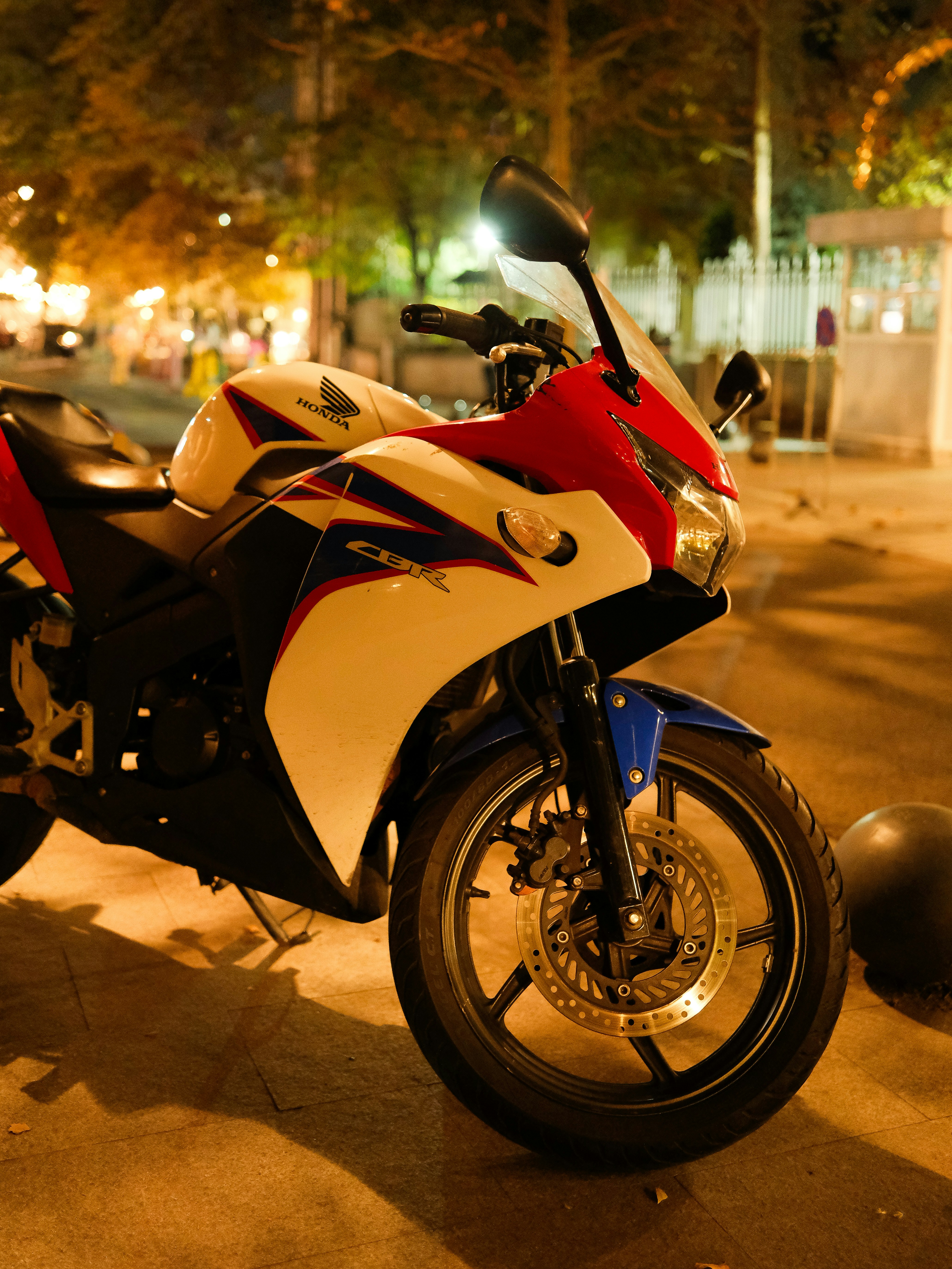 A white and red sport motorcycle parked at night. photo – Free Urban ...