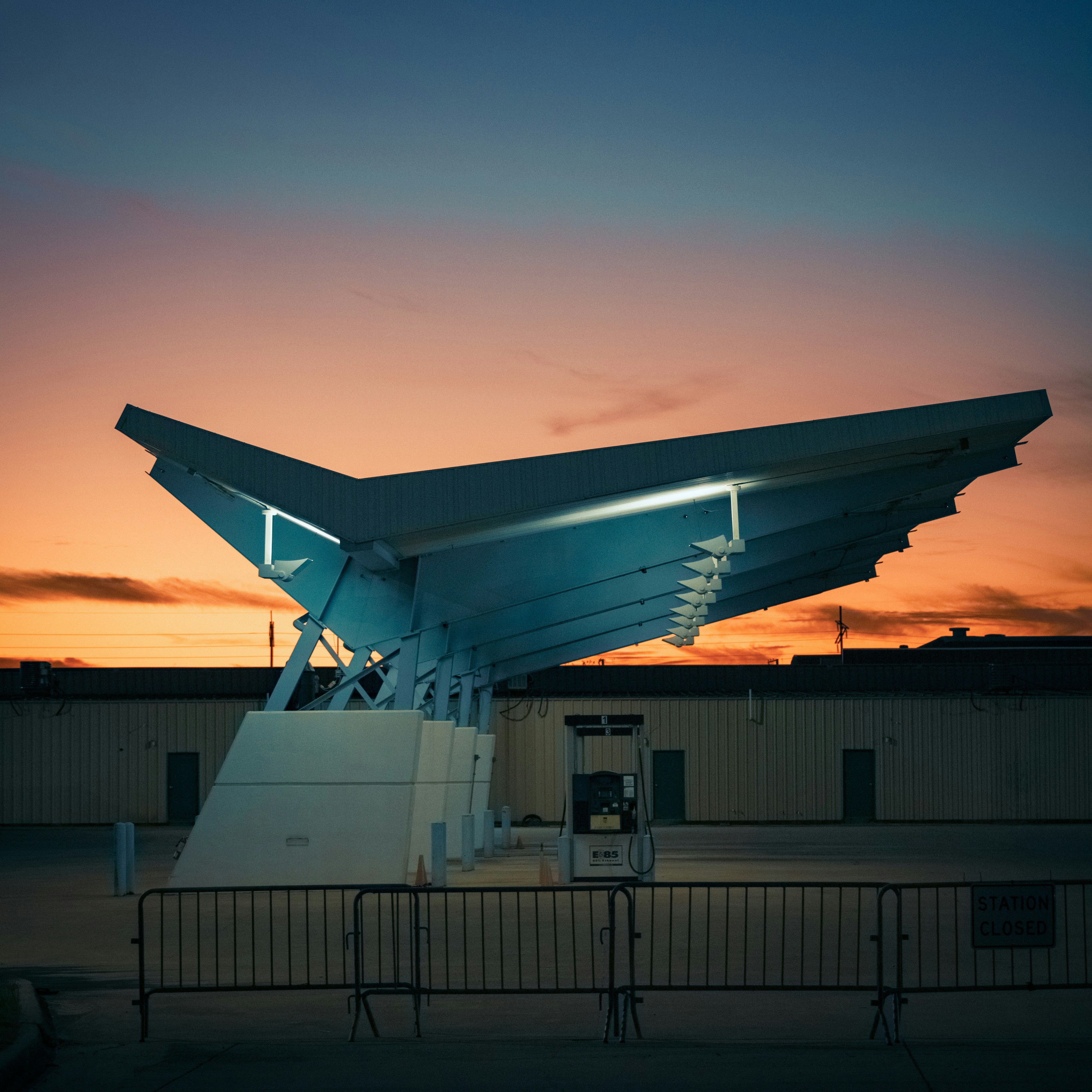Modern structure illuminated against sunset sky